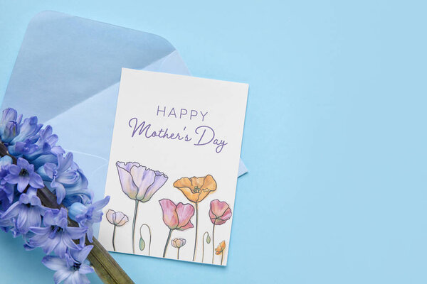 Карточка с текстом День Матери, конверт и гиацинтовый цветок на синем фоне