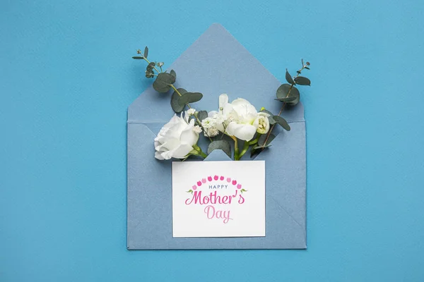 Composition with envelope, card and beautiful flowers on color background. Mother\'s day celebration