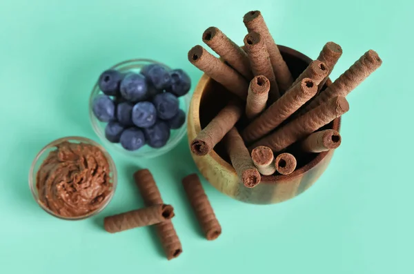 Schalen Met Heerlijke Chocoladewafeltjes Bosbessen Turquoise Achtergrond — Stockfoto