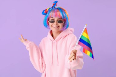 Beautiful young woman with LGBT flag on lilac background