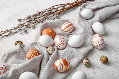 Composition with beautiful Easter eggs and willow branches on light background