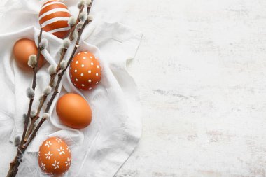 Composition with Easter eggs and willow branches on light background