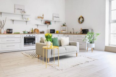 Interior of kitchen with Easter decor, white counters and sofa