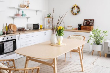 Interior of kitchen with Easter decor, white counters and dining table