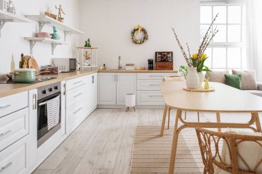 Interior of kitchen with Easter decor, white counters and dining table