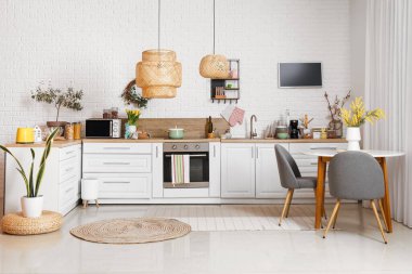 Interior of light kitchen with Easter decor, dining table and white counters