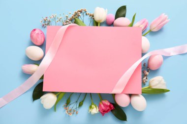 Composition with blank card, beautiful flowers and Easter eggs on color background