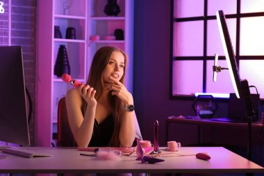 Thoughtful female blogger with vibrator conducting sex education online at home