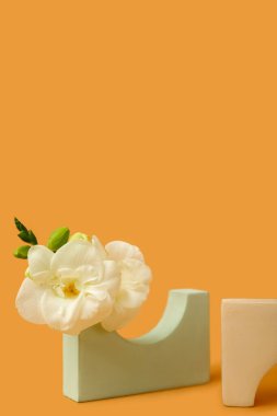 Podiums with beautiful flowers on orange background. Hello spring