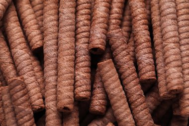 Delicious chocolate wafer rolls as background
