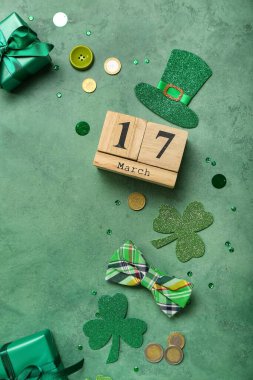Frame made of decor, calendar, gifts and coins on green background. St. Patrick's Day celebration