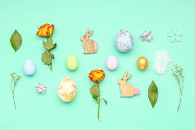 Composition with Easter eggs, flowers and decor on color background