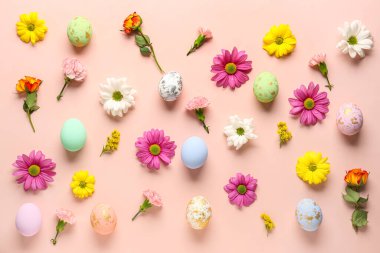 Composition with painted Easter eggs and different flowers on pink background