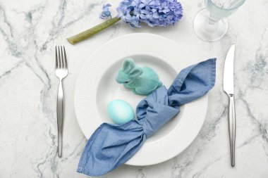 Table setting with Easter egg, bunny and hyacinth flowers on white marble background