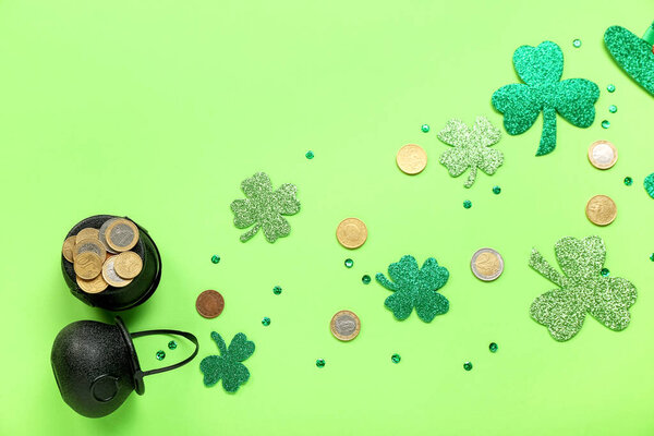 Горшки с монетами, бумажными клеверами и блестками на зеленом фоне. Празднование Дня Святого Патрика