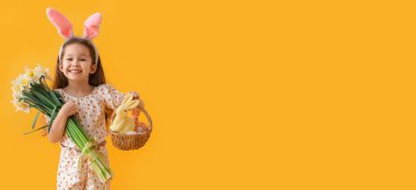 Cute little girl with Easter eggs, bunnies in basket and flowers on yellow background with space for text