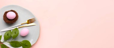 Stylish table setting for Easter dinner on light pink background with space for text
