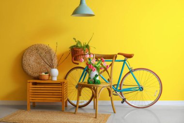 Interior of room decorated for Easter celebration with bicycle and tulips in vase