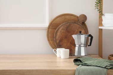Geyser coffee maker and cups on counter in kitchen
