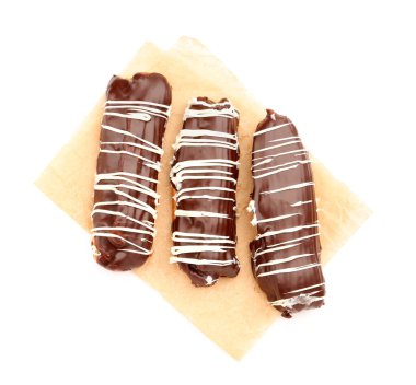 Parchment with sweet chocolate eclairs isolated on white background