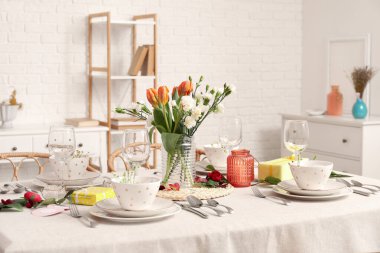 Table setting for International Women's Day celebration and vase with flowers in dining room