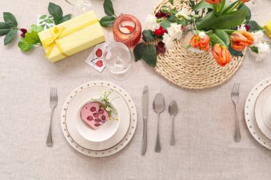 Setting for International Women's Day celebration with flowers and gift boxes on table