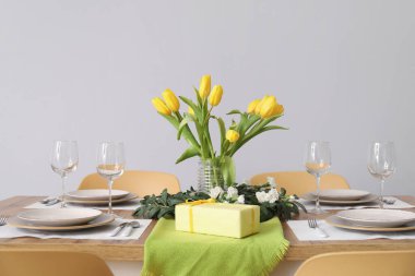 Table setting for International Women's Day celebration with gifts and tulip flowers on white background