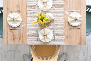 Setting for International Women's Day celebration with tulip flowers and teapot on table
