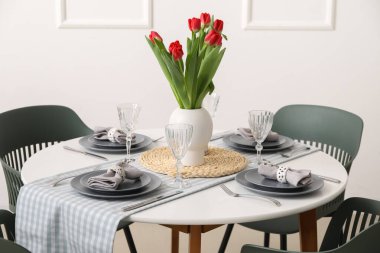 Table setting for International Women's Day celebration with tulip flowers in light room