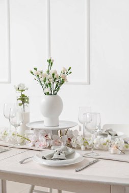 Beautiful table setting for International Women's Day celebration with eustoma and orchid flowers in light room