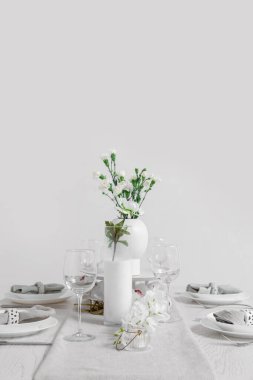 Beautiful table setting for International Women's Day celebration with eustoma and orchid flowers in light room