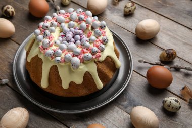 Composition with tasty Easter cake and eggs on wooden background