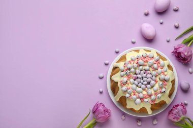 Composition with tasty Easter cake, eggs, candies and tulip flowers on color background