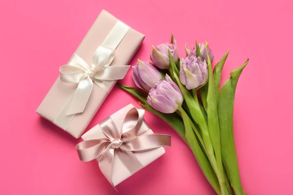 Gifts with tulips on pink background. Hello spring