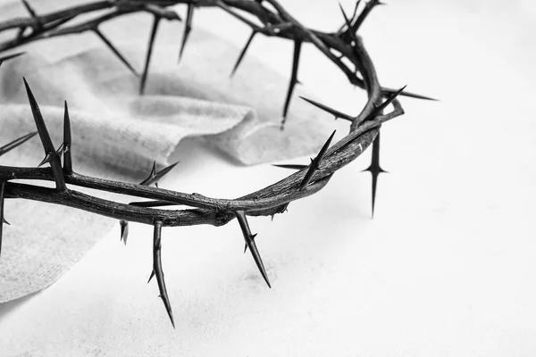 Crown of thorns and cloth on white background, closeup