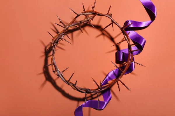 Crown of thorns with purple ribbon on red background. Good Friday concept