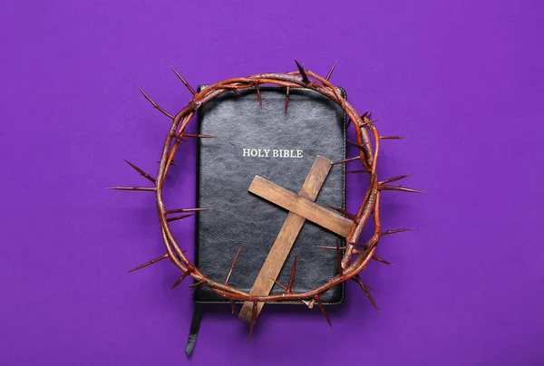 Holy Bible with wooden cross and crown of thorns on purple background. Good Friday concept