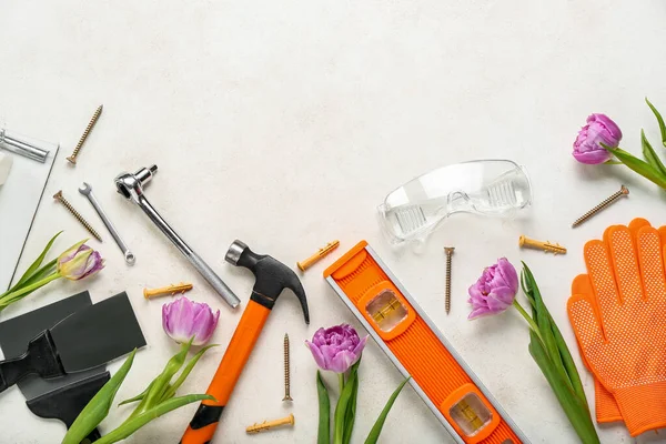 Builder\'s tools with tulips on white background. Hello spring