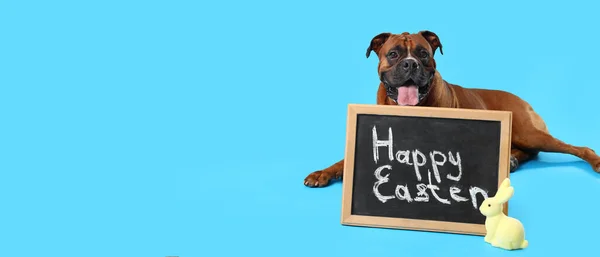 Boxer dog and chalkboard with text HAPPY EASTER on light blue background with space for text