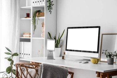 Açık ofiste bilgisayar ve tabletle modern işyeri