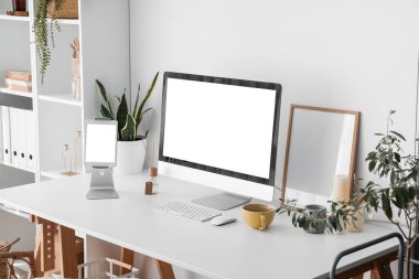 Işık duvarının yanında bilgisayar ve tabletle modern işyeri