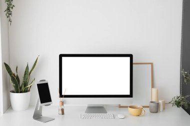 Işık duvarının yanında bilgisayar ve tabletle modern işyeri