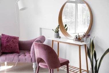 Interior of light makeup room with table, mirror and chairs