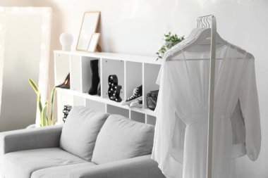 Rack with light clothes in modern dressing room