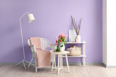 Vase with tulips, Easter bunnies and teapot on end table in living room