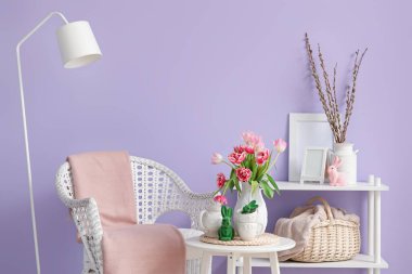 Vase with tulips, Easter bunnies and teapot on end table in living room