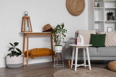 Interior of living room with sofa, tables and house candle holders