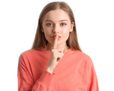 Young woman in red sweatshirt showing silence gesture on white background, closeup
