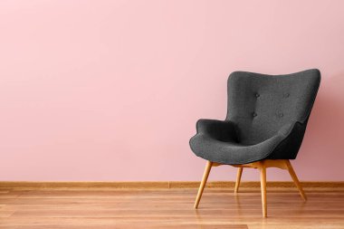Stylish grey armchair near pink wall
