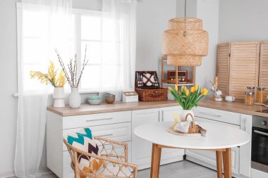 Interior of kitchen with Easter decor, white counters and dining table